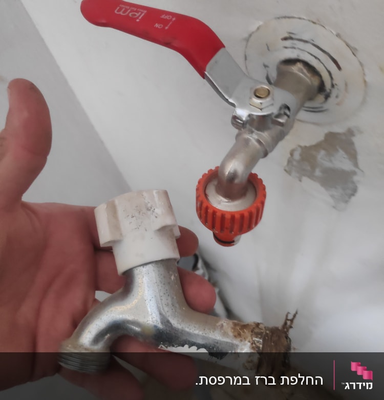 ברז מתכת מנותק עם ידית אדומה ותפוסה חלודה